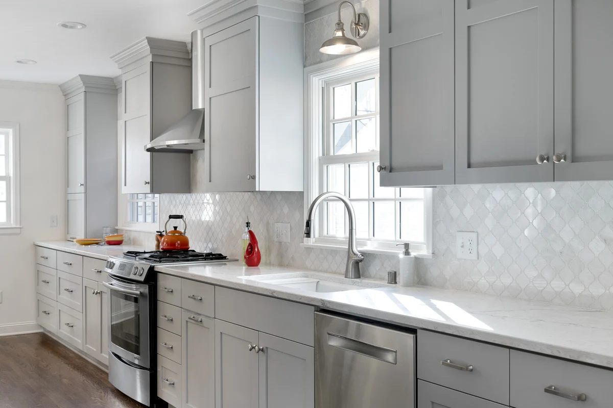Completed kitchen remodel on West Highland Parkway: painted shaker cabinetry and quartz counters, original windows kept